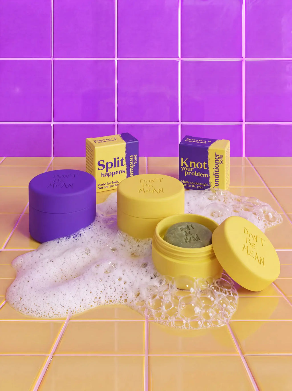 Mini Just in Case silicone cases in purple and yellow, one open with a shampoo bar, next to travel bar boxes