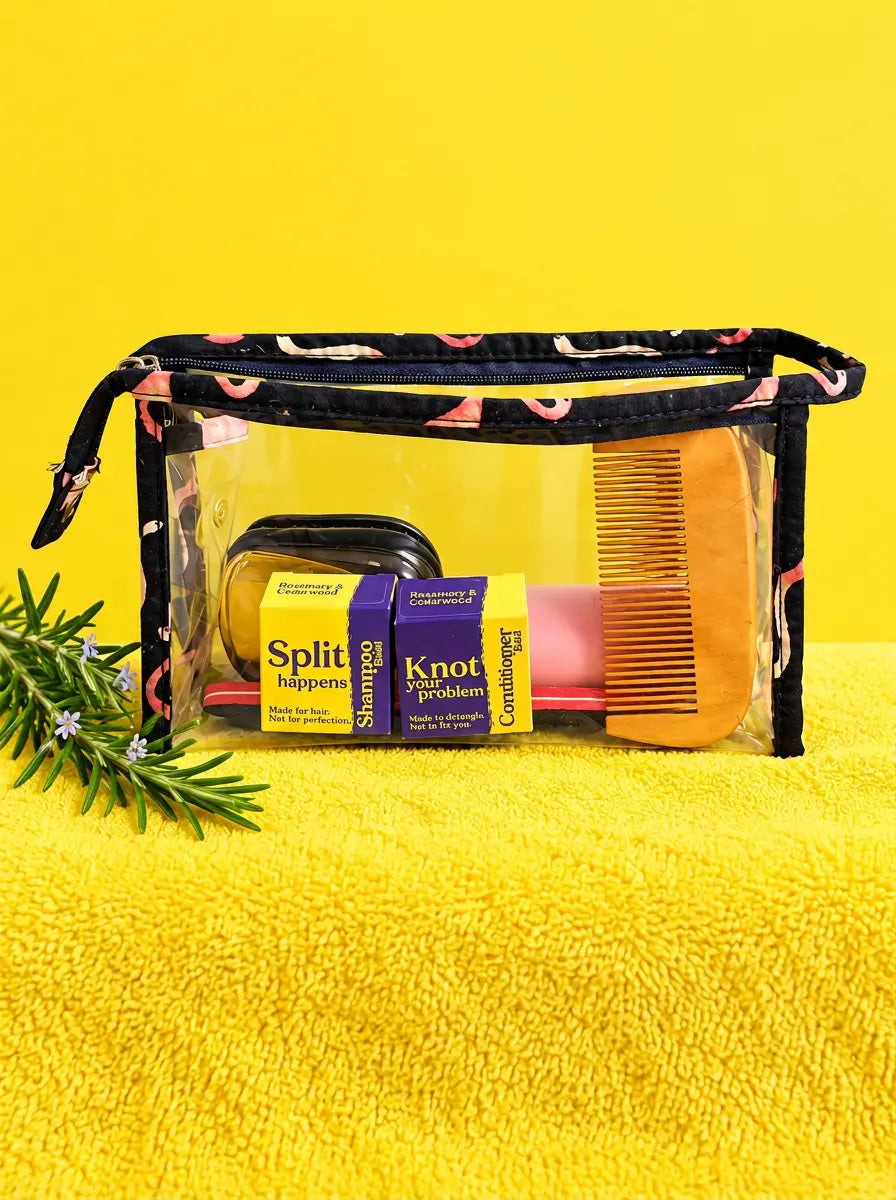 Clear toiletry bag packed with travel-size shampoo and conditioner boxes and a comb