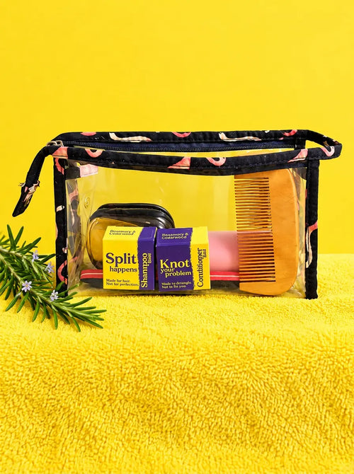 Clear toiletry bag packed with travel-size shampoo and conditioner boxes and a comb